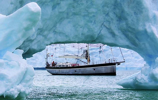 Steel sailboat in the arctic surrounded by ice and glaciers