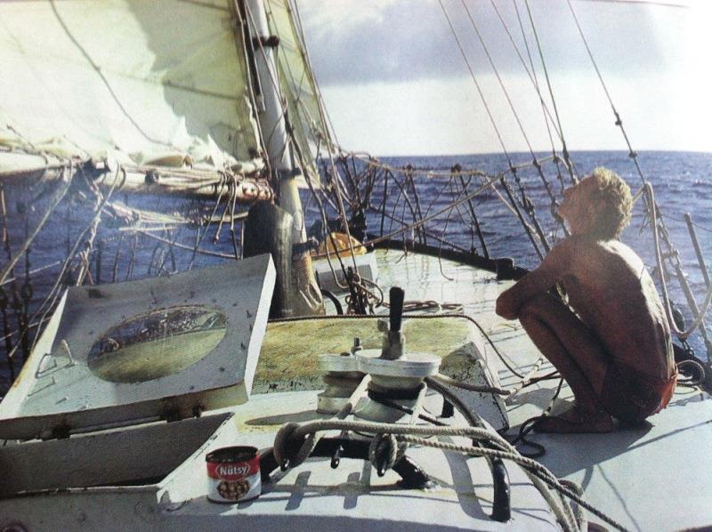Bernard Moitessier sitting on his boat Joshua looking up at the sails