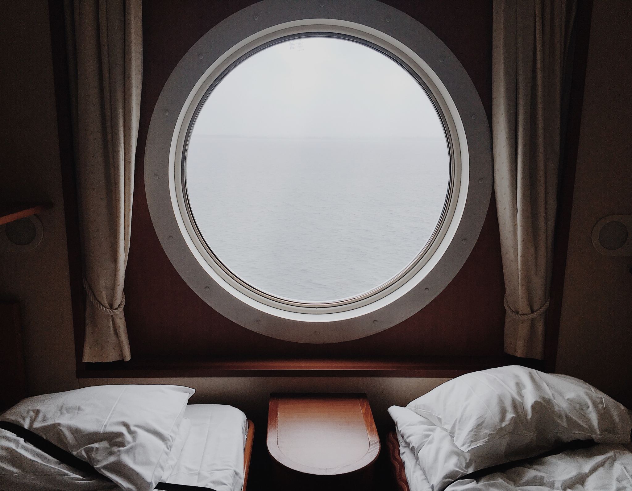 Boredom while living on a boat, shown through a porthole of a boat's interior Boredom while living on a boat, shown through a porthole of a boat's interior